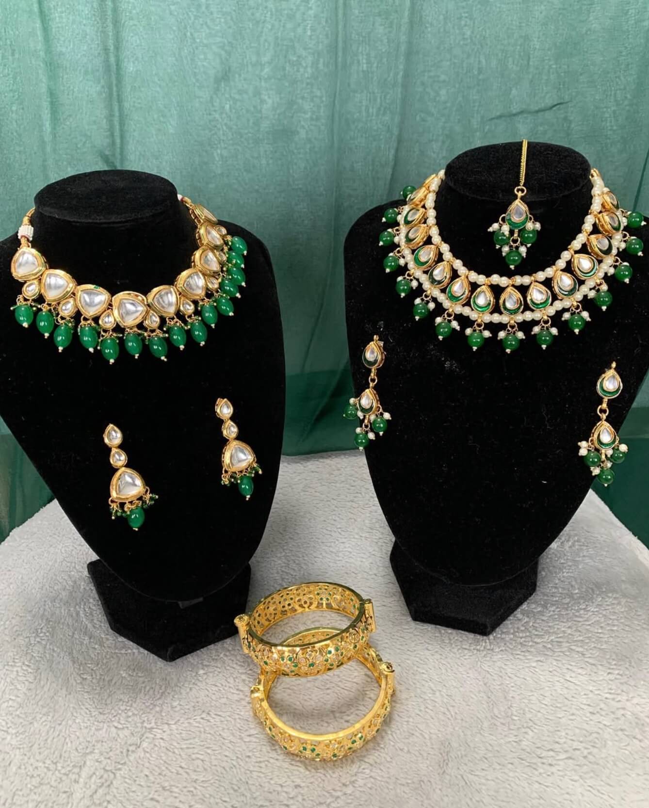 Statement earrings with gold and red stones displayed on soft velvet tray