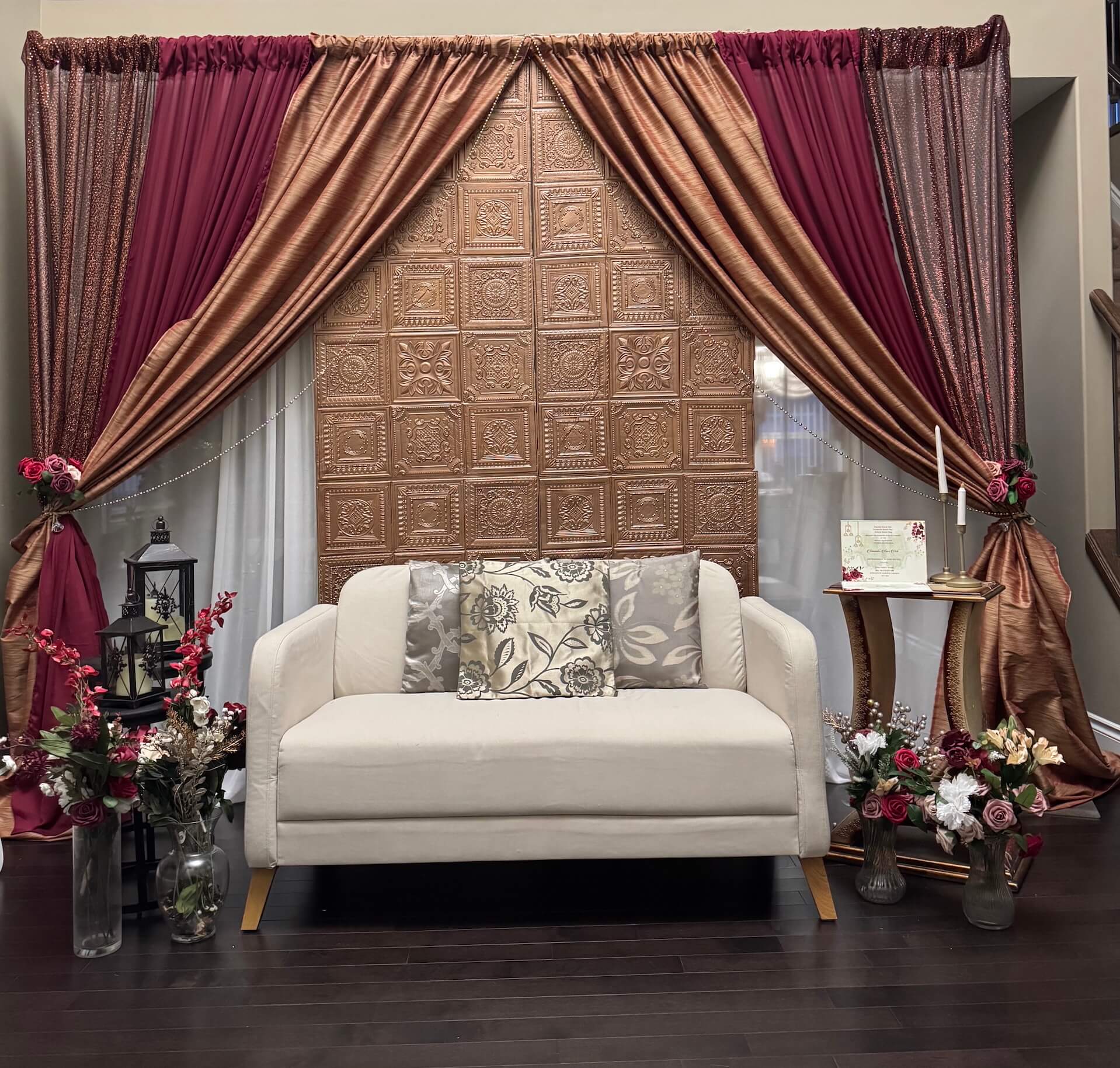 Elegant wedding reception setup with white drapes and floral backdrop by Mira Creations