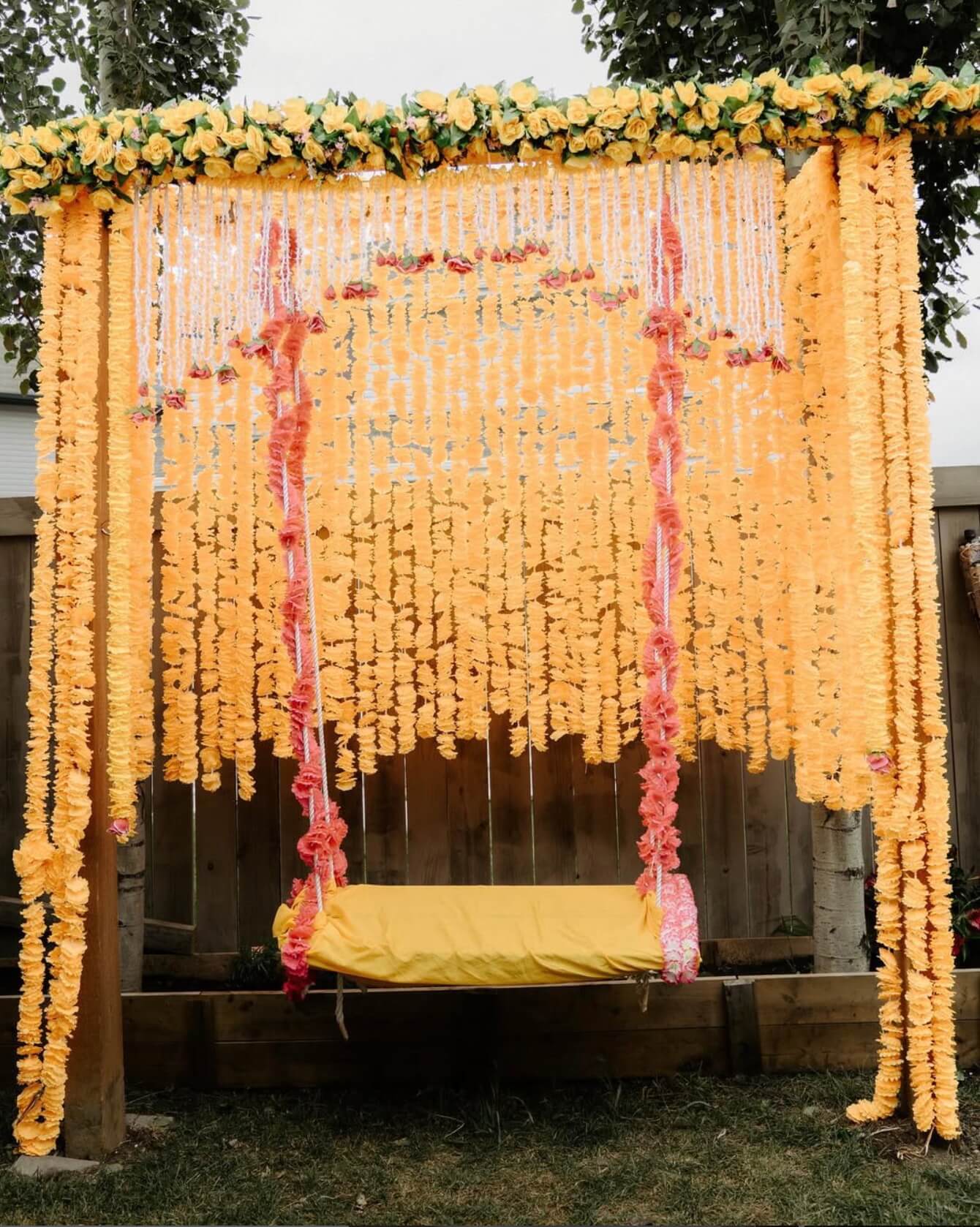 Stage layout for Sikh wedding with cream draping and soft floral arrangements
